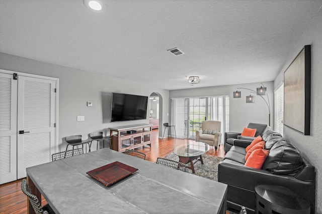 living room featuring wood-type flooring and a textured ceiling