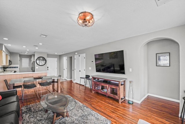 living room with hardwood / wood-style flooring, a textured ceiling, and sink