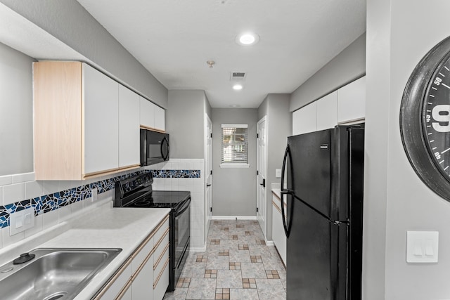 kitchen featuring black appliances, white cabinetry, and sink