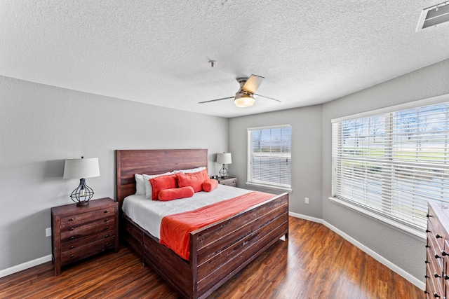 bedroom featuring ceiling fan, a textured ceiling, and dark wood-type flooring