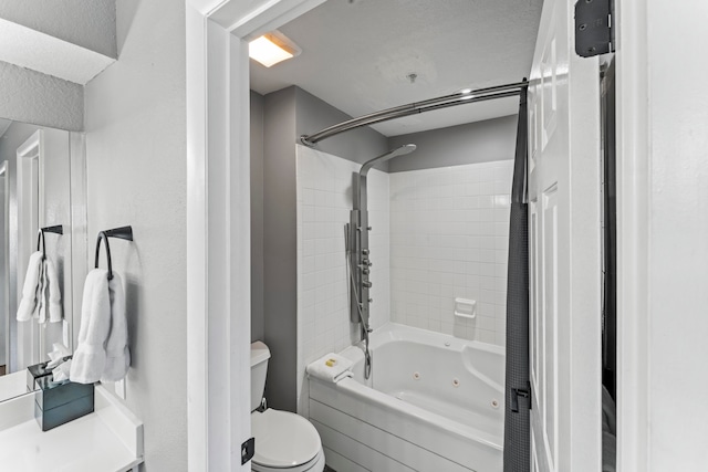 full bathroom with vanity, tiled shower / bath combo, and toilet