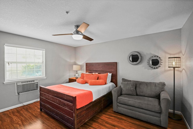 bedroom with cooling unit, ceiling fan, dark wood-type flooring, and a textured ceiling