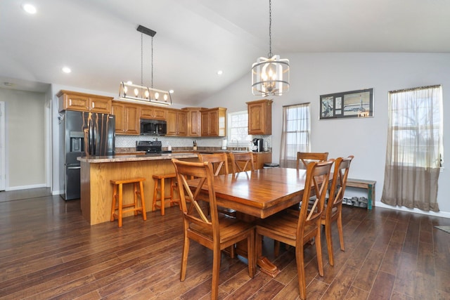 dining room with dark hardwood / wood-style floors, vaulted ceiling, a notable chandelier, and sink