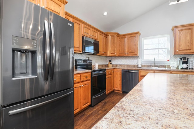 kitchen featuring tasteful backsplash, dark wood-type flooring, vaulted ceiling, sink, and black appliances