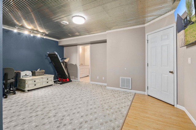 interior space with ornamental molding and hardwood / wood-style floors