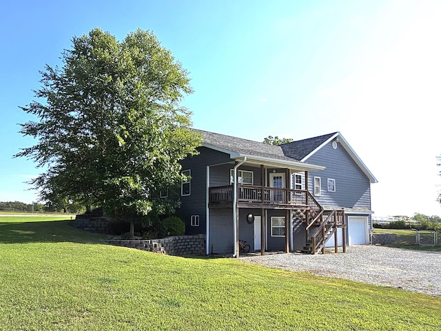 back of house featuring a garage and a yard