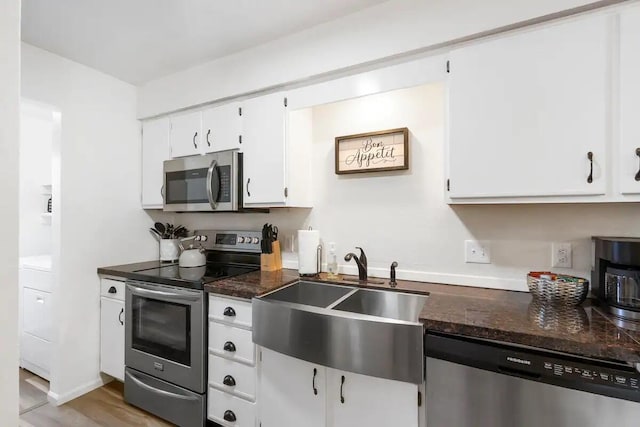 kitchen featuring white cabinets, appliances with stainless steel finishes, sink, and light hardwood / wood-style flooring