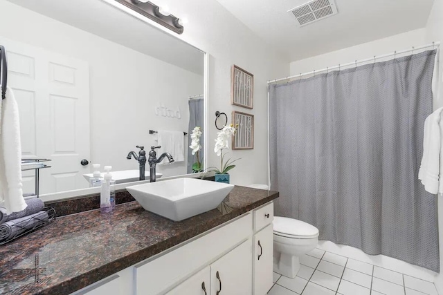 bathroom featuring a shower with shower curtain, vanity, toilet, and tile patterned floors