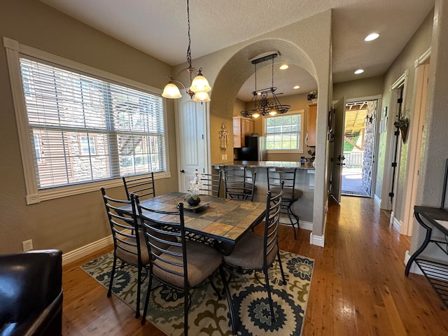 dining area featuring wood-type flooring and a textured ceiling