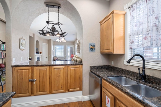 kitchen featuring sink, pendant lighting, a notable chandelier, light hardwood / wood-style flooring, and dishwasher