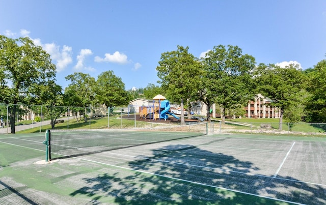 view of tennis court with a playground