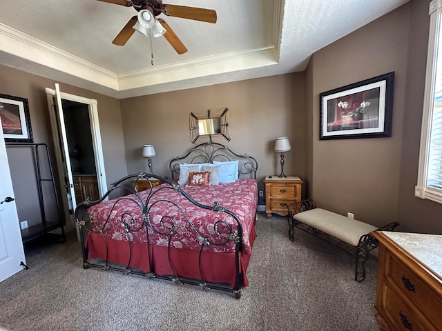 carpeted bedroom featuring ceiling fan, a tray ceiling, ornamental molding, and a textured ceiling