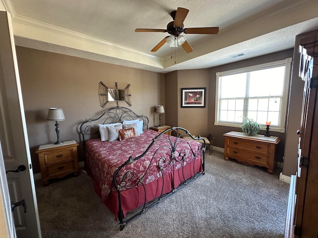 bedroom with ceiling fan, carpet floors, ornamental molding, a textured ceiling, and a raised ceiling