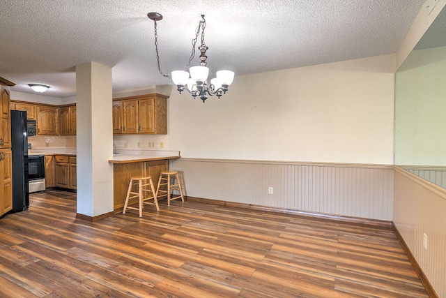 kitchen featuring kitchen peninsula, pendant lighting, dark hardwood / wood-style floors, and a textured ceiling