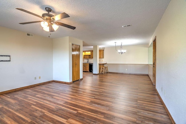 150 Sunken Forest Dr Unit 10-242, Forsyth, MO 65653 - spare room featuring ceiling fan with notable chandelier, visible vents, a textured ceiling, and dark wood-style flooring