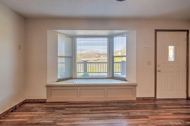 foyer featuring a textured ceiling and dark hardwood / wood-style flooring