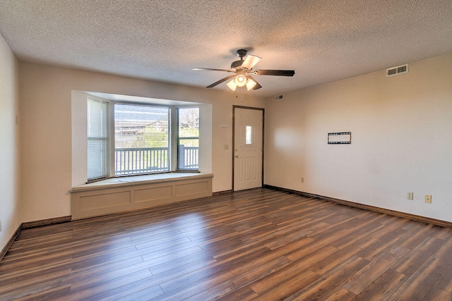 unfurnished room with ceiling fan, dark hardwood / wood-style floors, and a textured ceiling