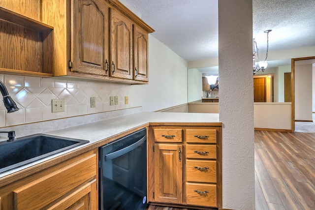 kitchen with hanging light fixtures, sink, a chandelier, dark wood-type flooring, and dishwasher