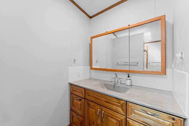 kitchen with ornamental molding, light stone counters, sink, and a textured ceiling