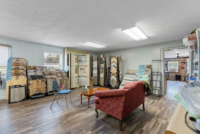 living room featuring wood-type flooring and a textured ceiling