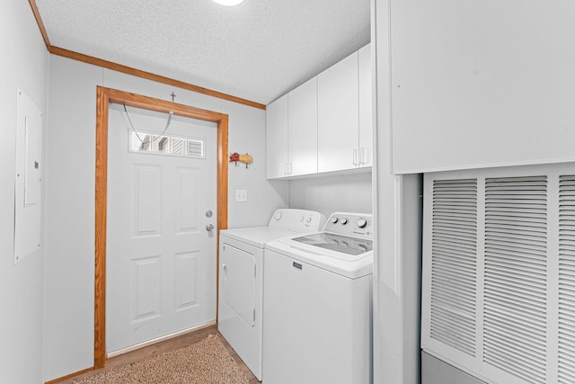 washroom with washing machine and dryer, cabinets, ornamental molding, and a textured ceiling