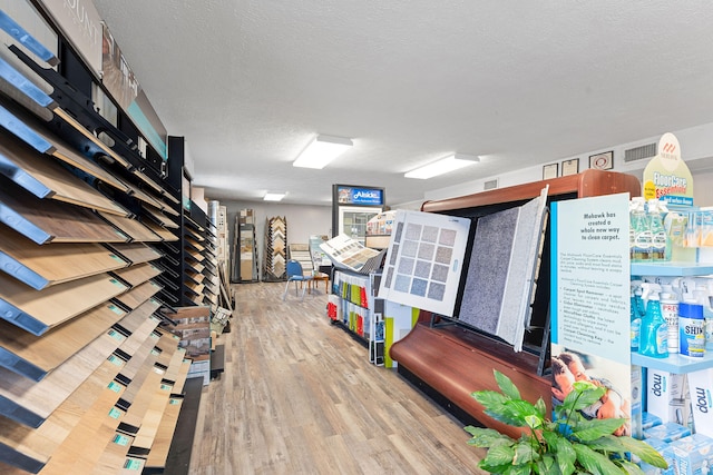 interior space featuring light wood-type flooring and a textured ceiling