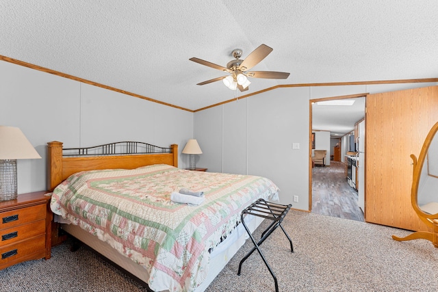 bedroom featuring ceiling fan, carpet floors, vaulted ceiling with skylight, and a textured ceiling