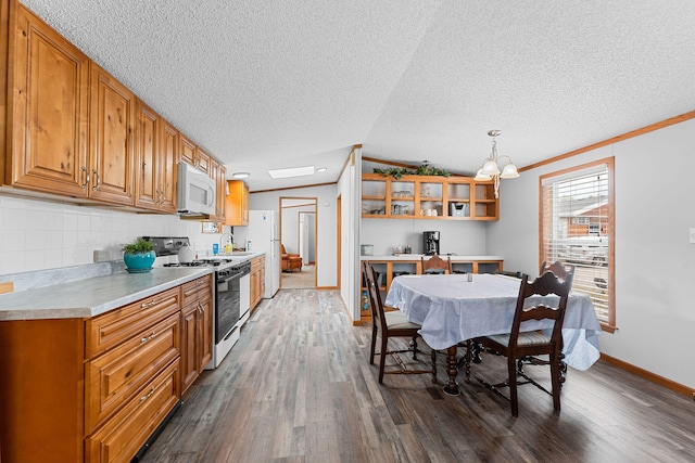 kitchen with pendant lighting, white appliances, dark wood-type flooring, ornamental molding, and a textured ceiling