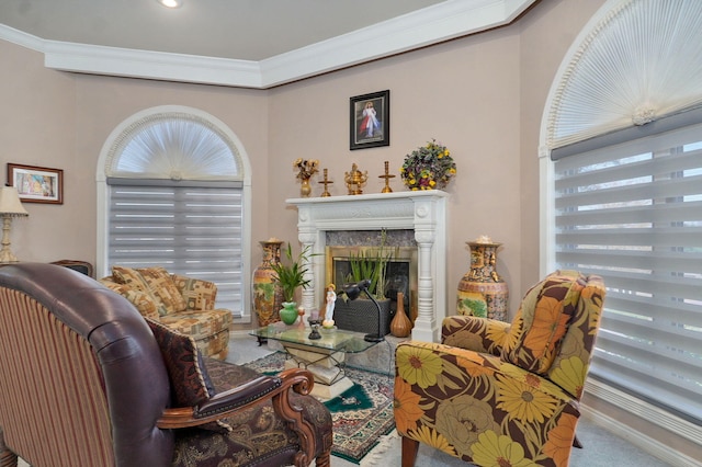 sitting room with a fireplace, ornamental molding, and carpet