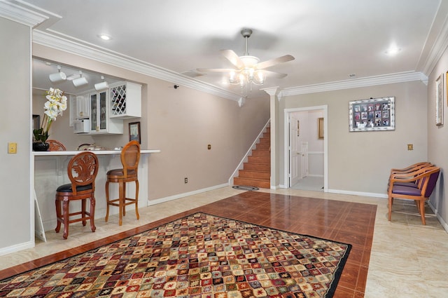 tiled entryway featuring ornamental molding and ceiling fan