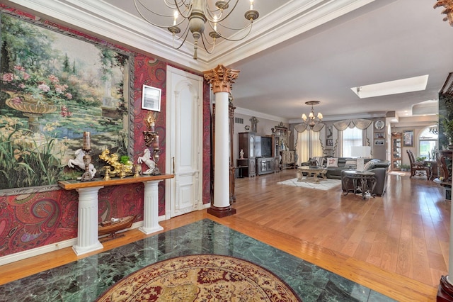 foyer entrance featuring ornamental molding, hardwood / wood-style floors, and an inviting chandelier