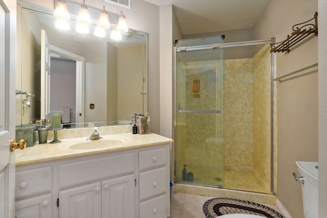 bathroom featuring vanity, a shower with shower door, toilet, and tile patterned flooring