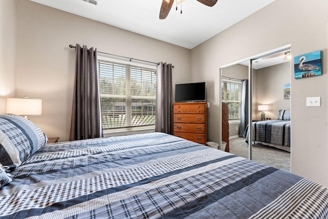 bedroom with multiple windows, ceiling fan, carpet floors, and a closet