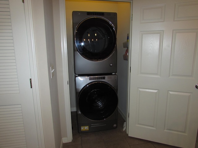 280 Tina St Unit 9, Hollister, MO 65672 - laundry area featuring baseboards, dark tile patterned floors, stacked washing maching and dryer, and laundry area