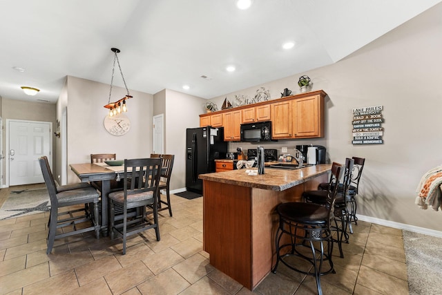 280 Tina St Unit 9, Hollister, MO 65672 - kitchen featuring a sink, baseboards, black appliances, a peninsula, and a breakfast bar area
