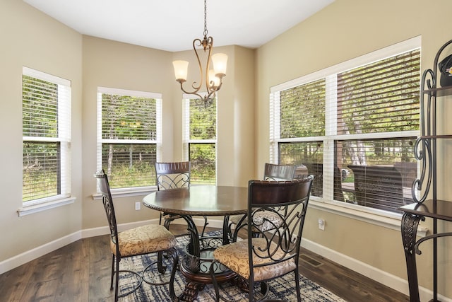 dining space featuring dark hardwood / wood-style floors and an inviting chandelier