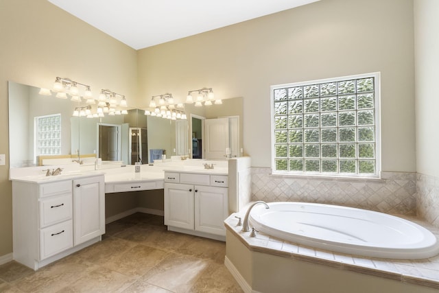 bathroom featuring tiled bath, tile patterned flooring, and vanity