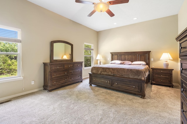 bedroom with multiple windows, light carpet, and ceiling fan