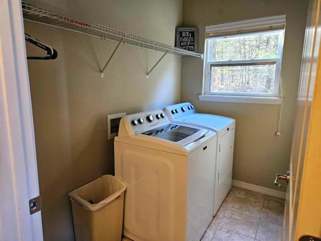 laundry area with washer and clothes dryer and light tile patterned floors