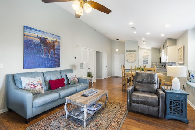 living room featuring dark wood-type flooring, vaulted ceiling, and ceiling fan