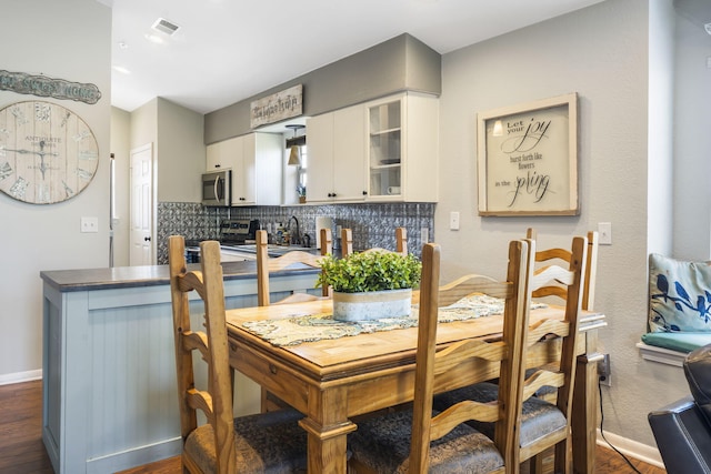 dining room featuring dark wood-type flooring and sink