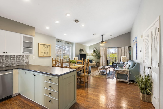 kitchen with lofted ceiling, kitchen peninsula, dark wood-type flooring, and white cabinetry