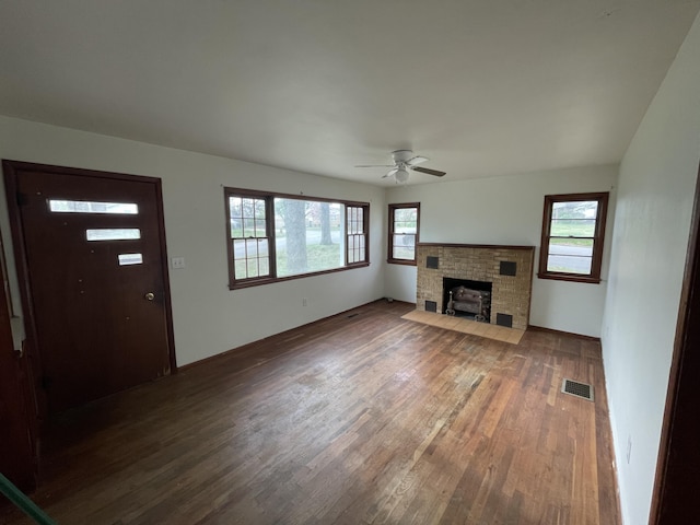 601 Texas St, West Plains, MO 65775 - unfurnished living room with ceiling fan, a brick fireplace, wood finished floors, and visible vents