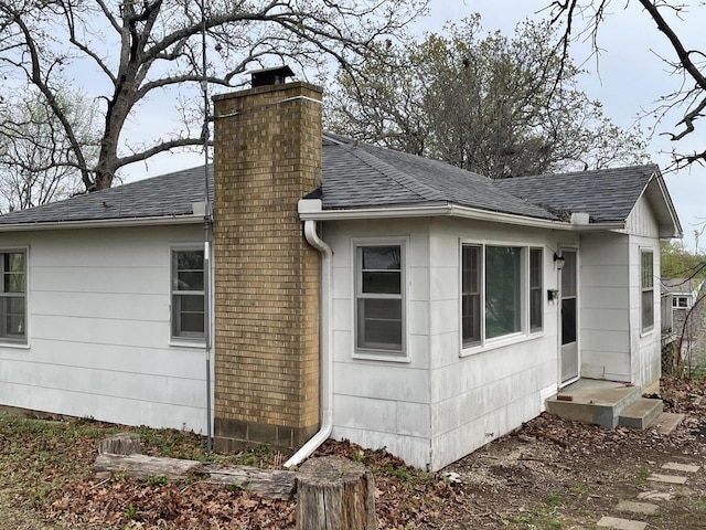 601 Texas St, West Plains, MO 65775 - view of side of property featuring roof with shingles and a chimney