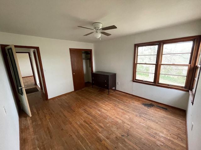 unfurnished bedroom featuring ceiling fan and dark hardwood / wood-style flooring