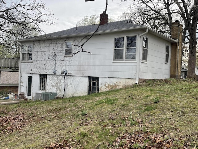 601 Texas St, West Plains, MO 65775 - view of side of home with a chimney, roof with shingles, and central AC