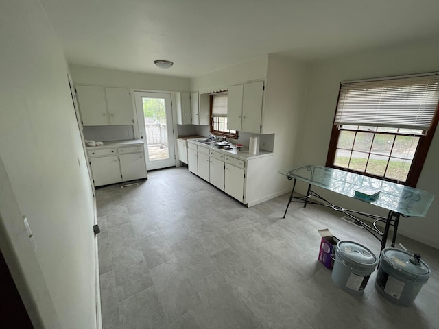 kitchen with white dishwasher and white cabinetry