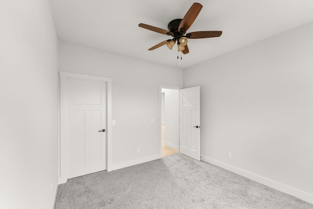 carpeted spare room with ceiling fan