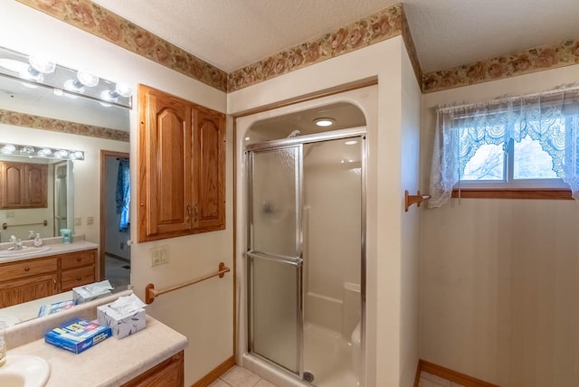 bathroom with tile patterned flooring, vanity, a shower with shower door, and a textured ceiling