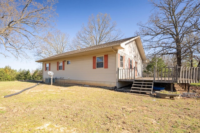 view of side of property with a deck and a lawn